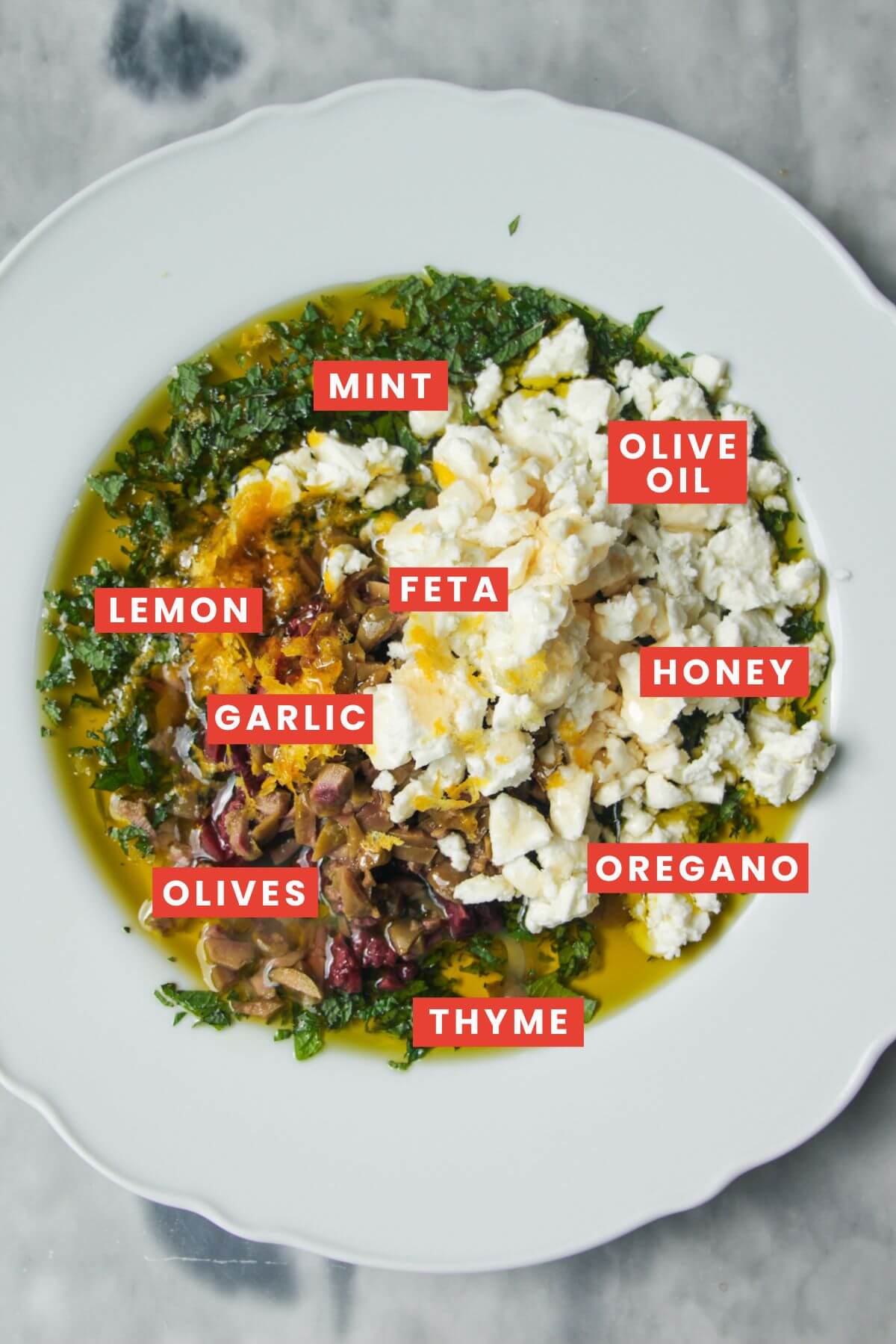 Ingredients in Greek dipping oil in a large white plate.