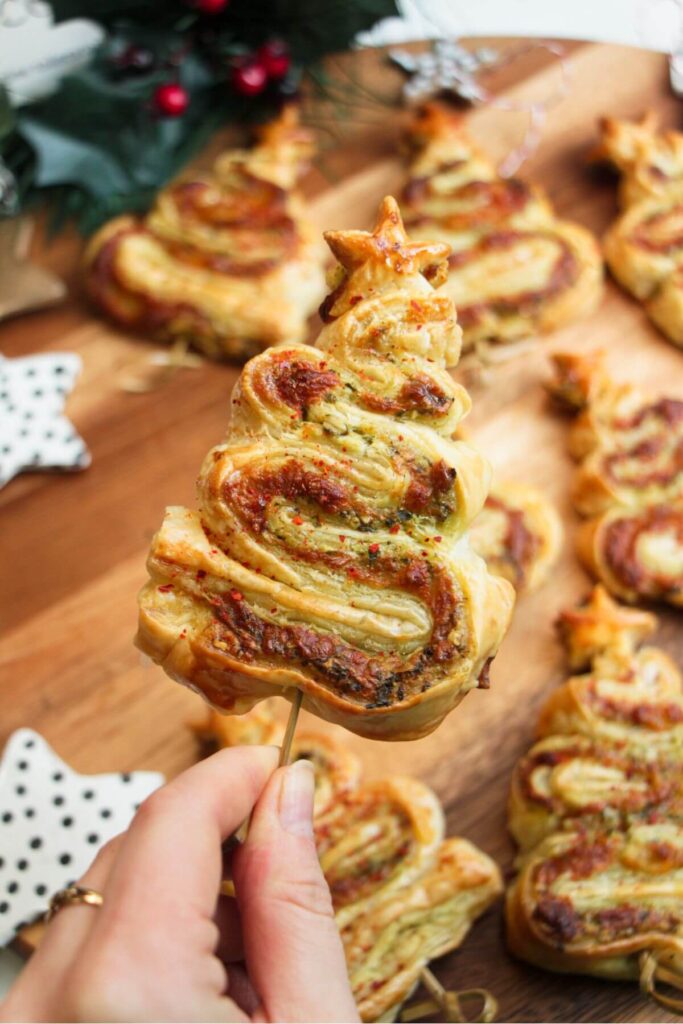 Holding up a skewered puff pastry Christmas tree.