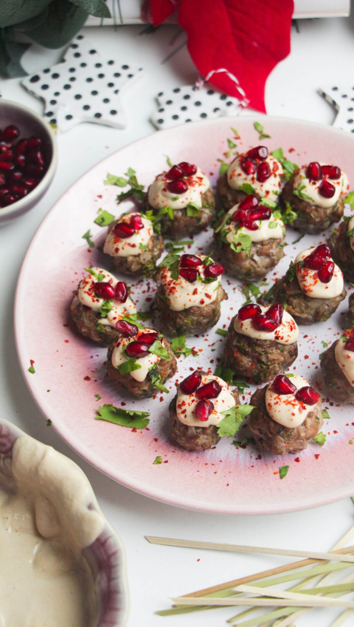 Decorated lamb meatballs on a small pink plate.