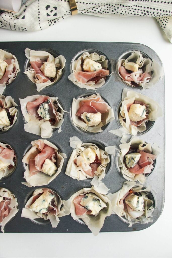 Unbaked blue cheese filo cups in a mini muffin tin.