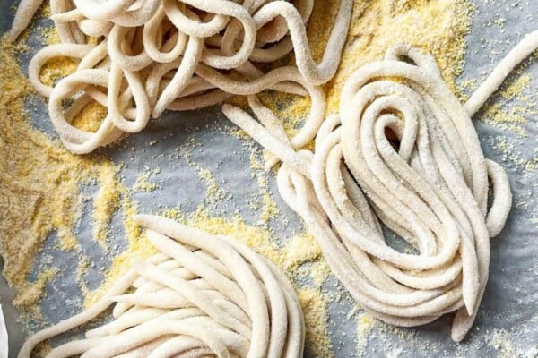 Pici pasta nestled on a lined baking tray.
