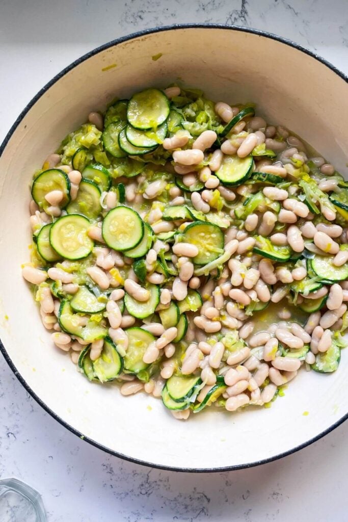 White beans, zucchini and leeks in a large pot.