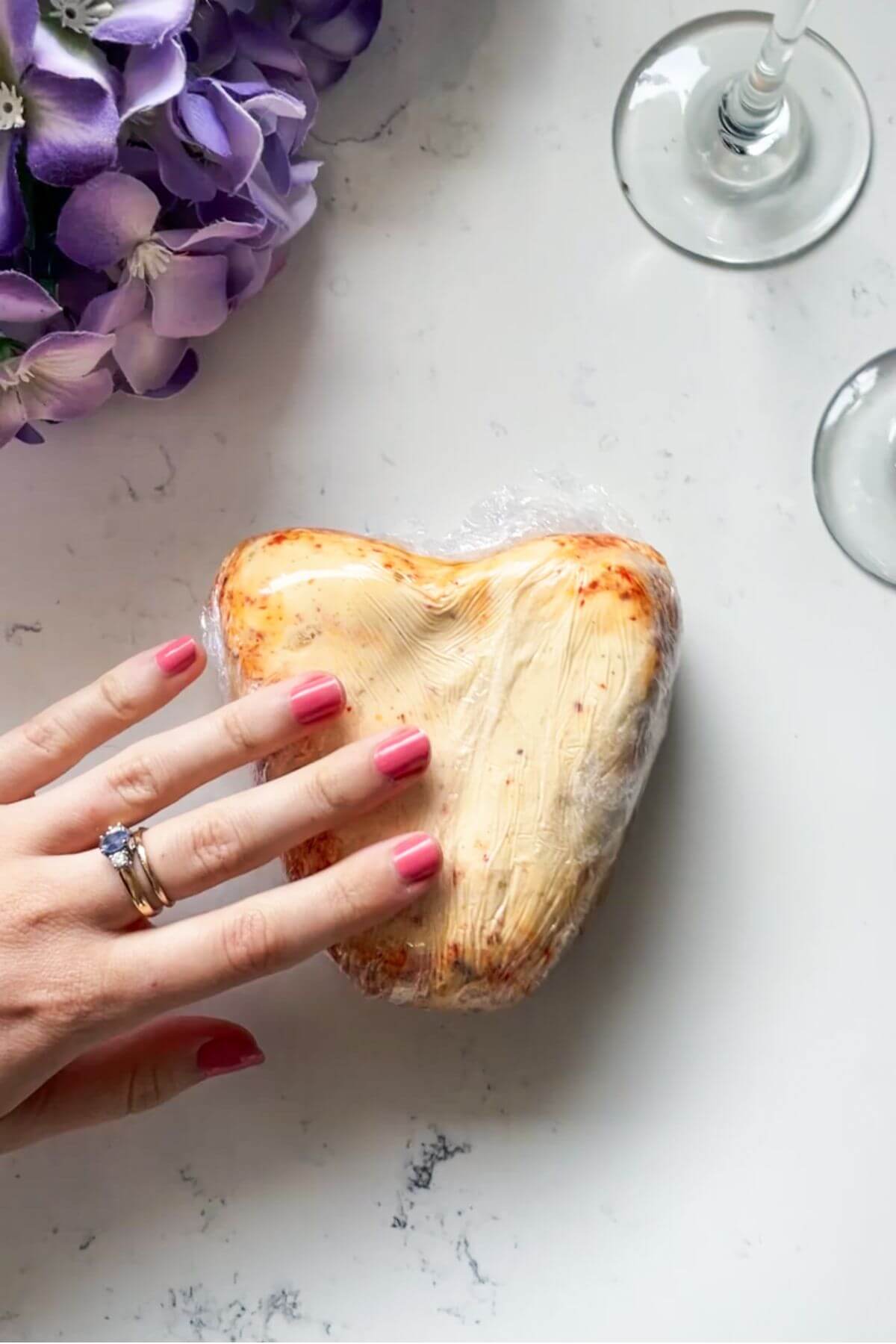 Heart shaped cheese wrapped in cling film.