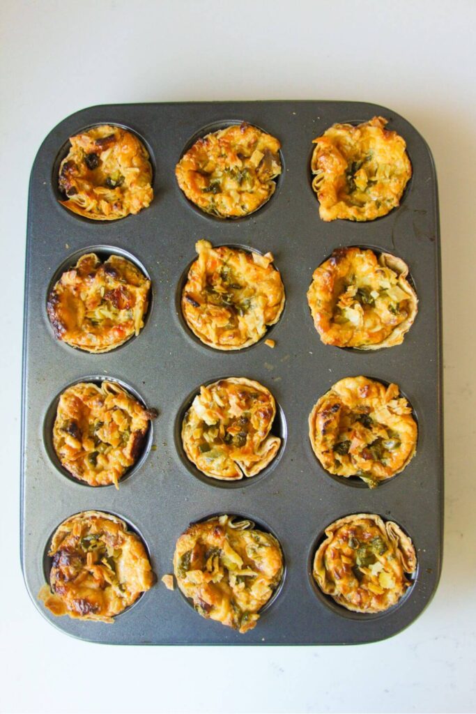 Baked jalapeno popper taco cups in a mini muffin tin.