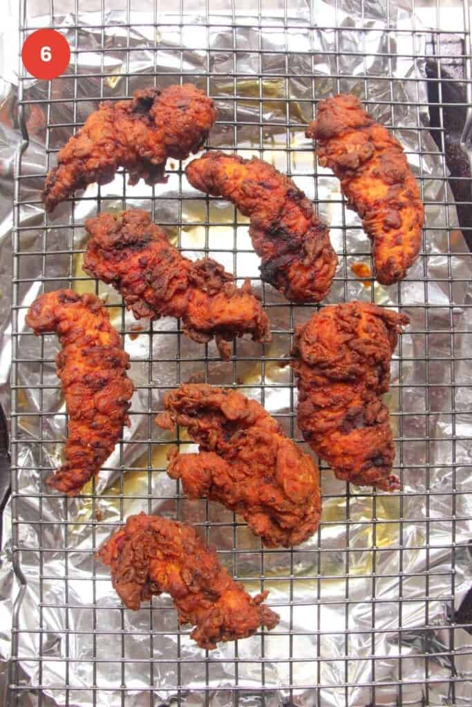 Fried chicken tenders on a wire rack.