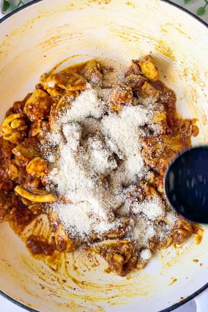 Ground almonds scattered on top of chicken in a pan.