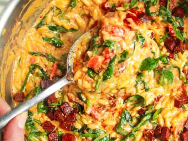 Creamy Marry Me orzo in a stainless steel pan with a silver spoon.