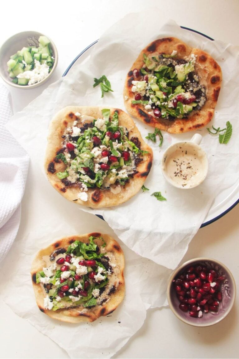 Three smash kebab tacos on a white background with cucumber and sauce on the side.