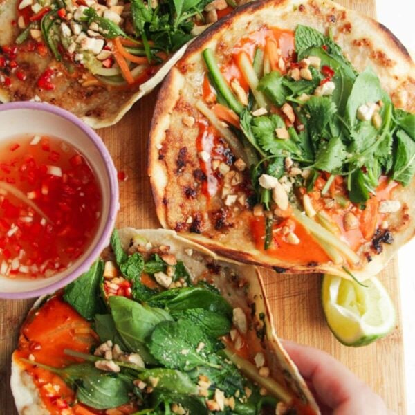 Three chicken banh mi tacos on a wooden board.