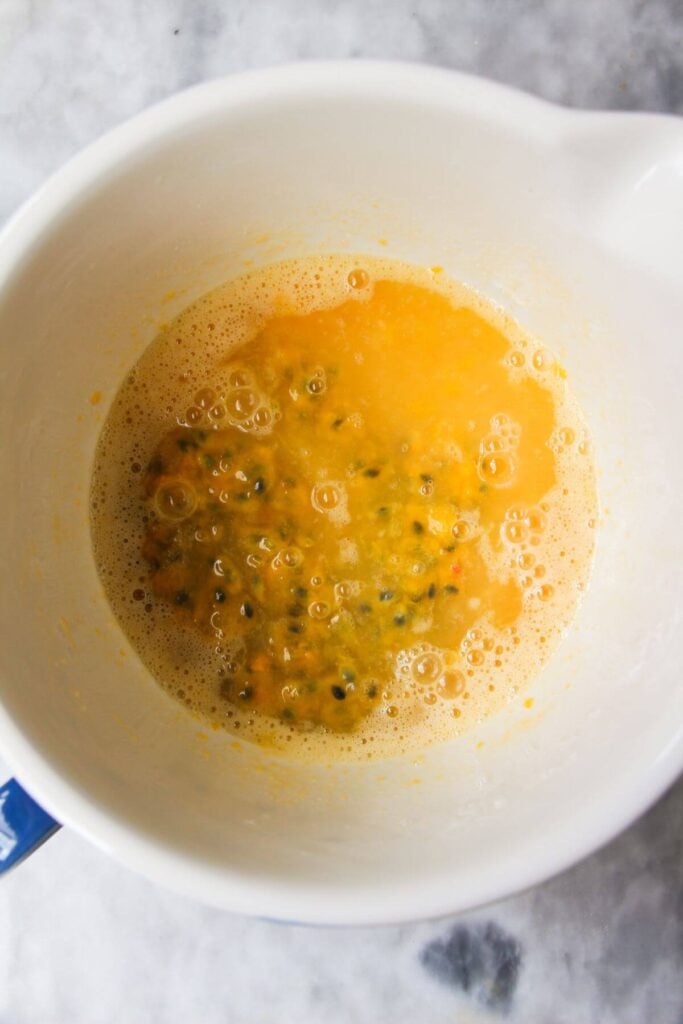 Ingredients for lemon passionfruit curd in a white and blue bowl.