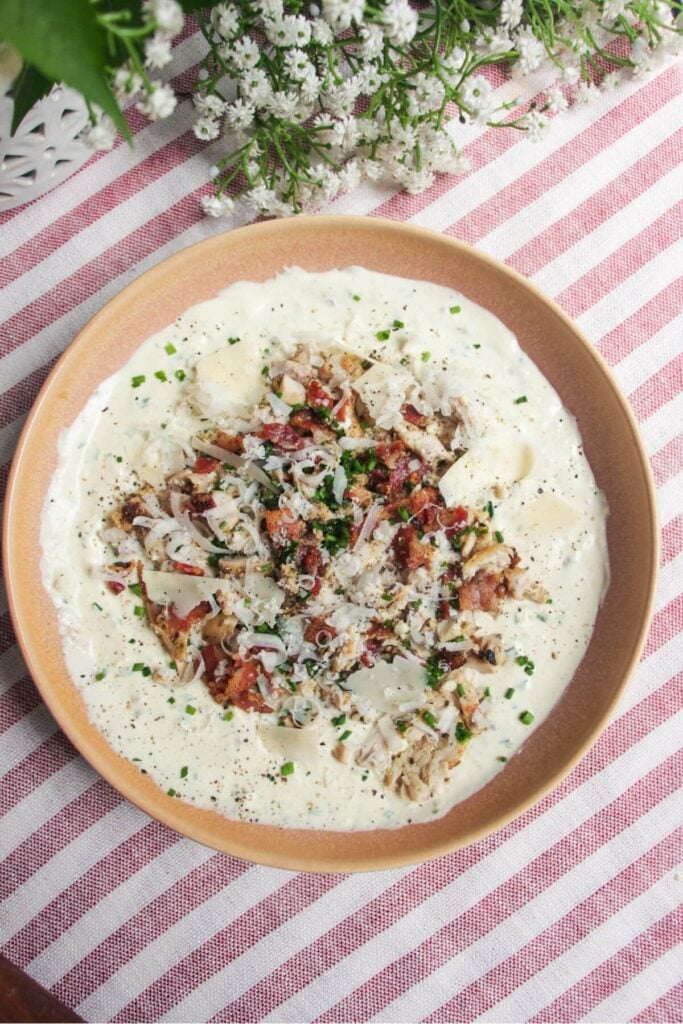 Chicken Caesar dip mixed and topped with extra chicken and bacon.