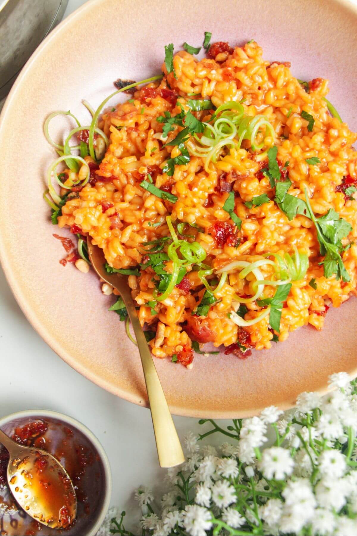 Gochujang risotto topped with scallions with sweet chilli jam on the side.