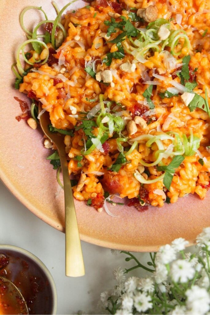 Close up of gochujang risotto in a pink bowl.