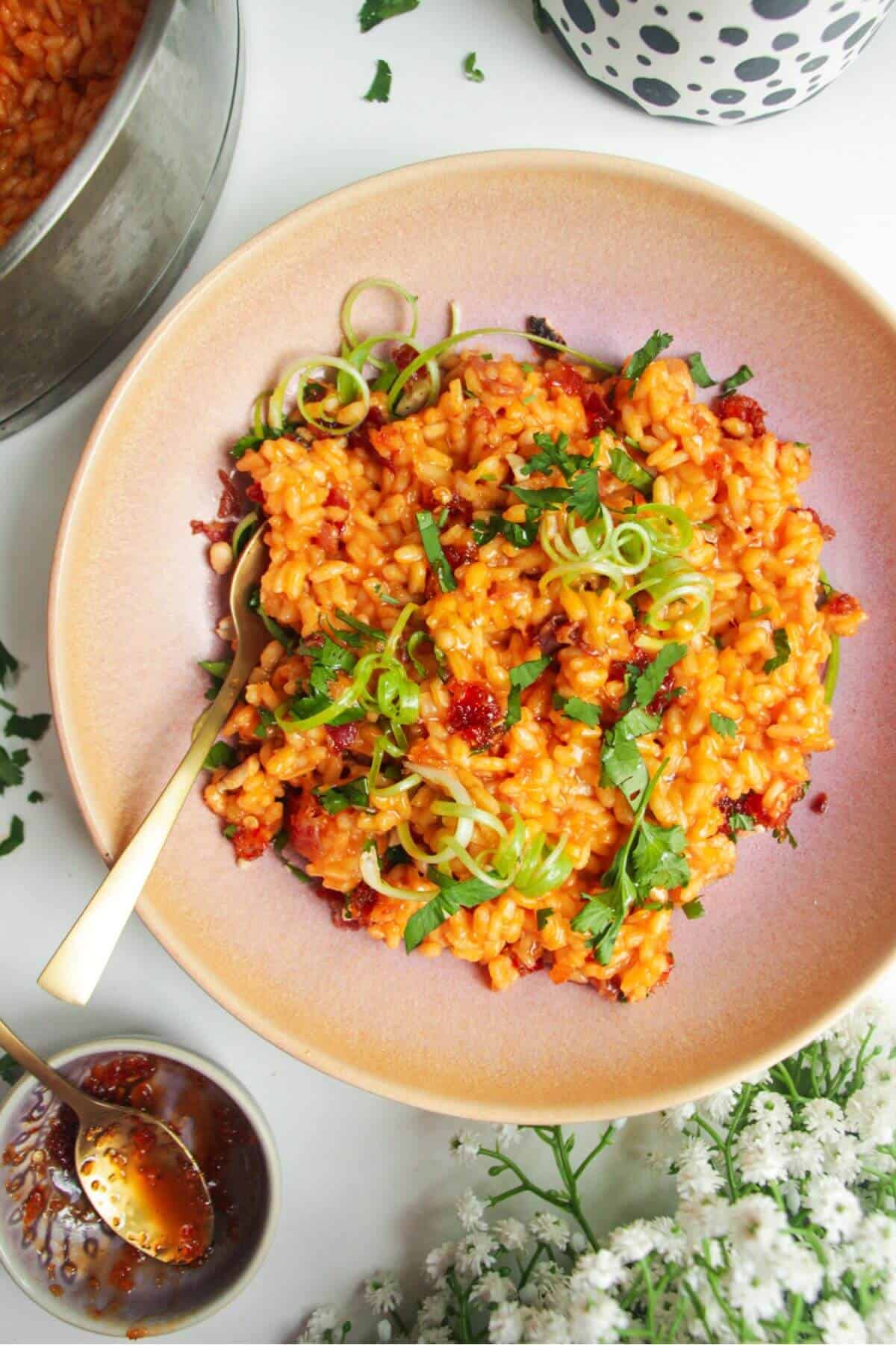 Gochujang risotto topped with scallions with sweet chilli jam on the side.