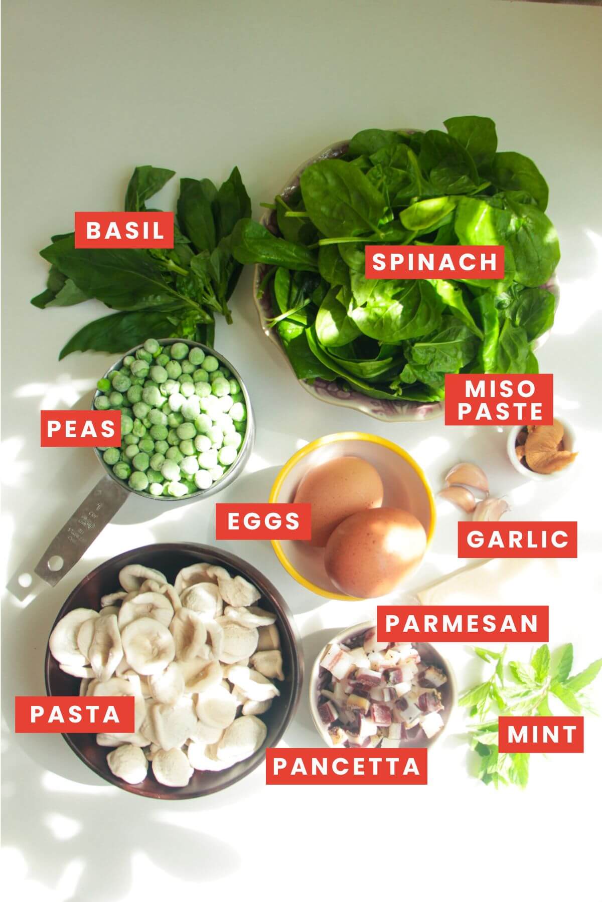 Ingredients for pea pancetta carbonara laid out and labelled.