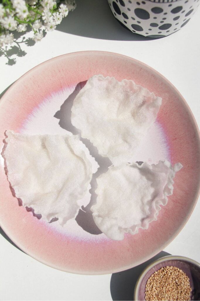 Three crispy rice paper cups on a pink plate.