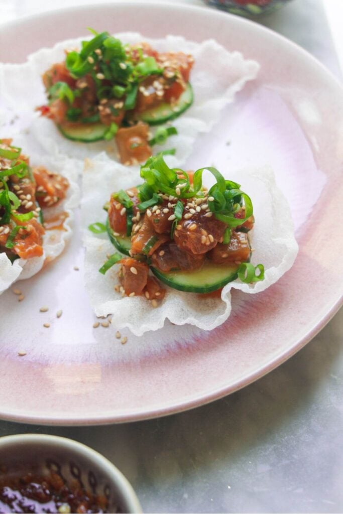 Close up of tuna rice paper cup on a pink plate.