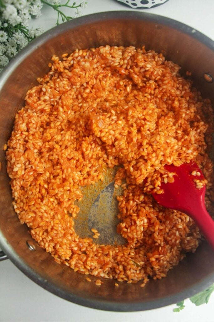 Wine added to a large pan with risotto in it.