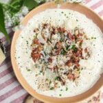 Chicken Caesar dip mixed and topped with extra chicken and bacon.