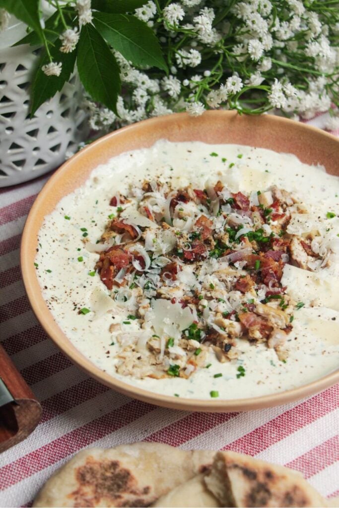 Chicken Caesar dip mixed and topped with extra chicken and bacon.