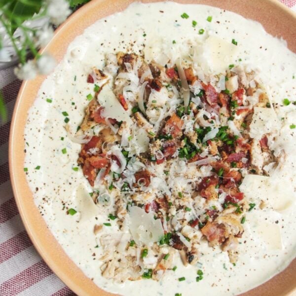 Chicken Caesar dip mixed and topped with extra chicken and bacon.