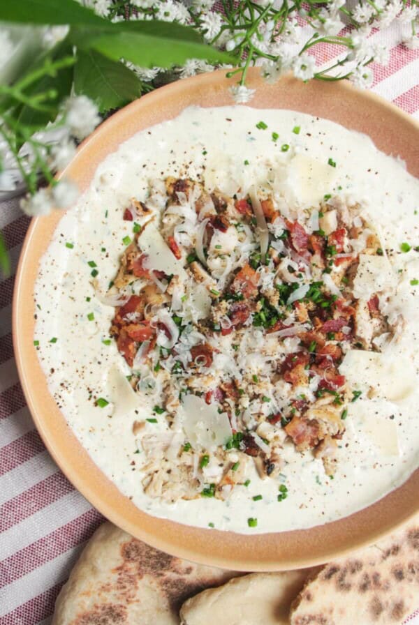 Chicken Caesar dip mixed and topped with extra chicken and bacon.