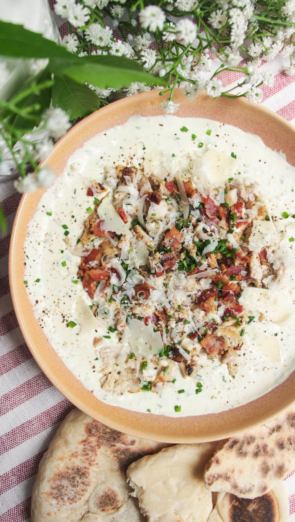 Chicken Caesar dip mixed and topped with extra chicken and bacon.