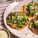 Three chicken Caesar tacos on a pink plate.