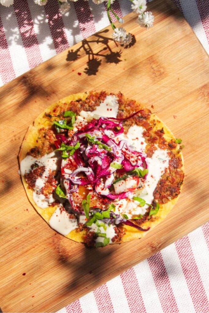 Smash falafel taco topped with slaw and tahini sauce.