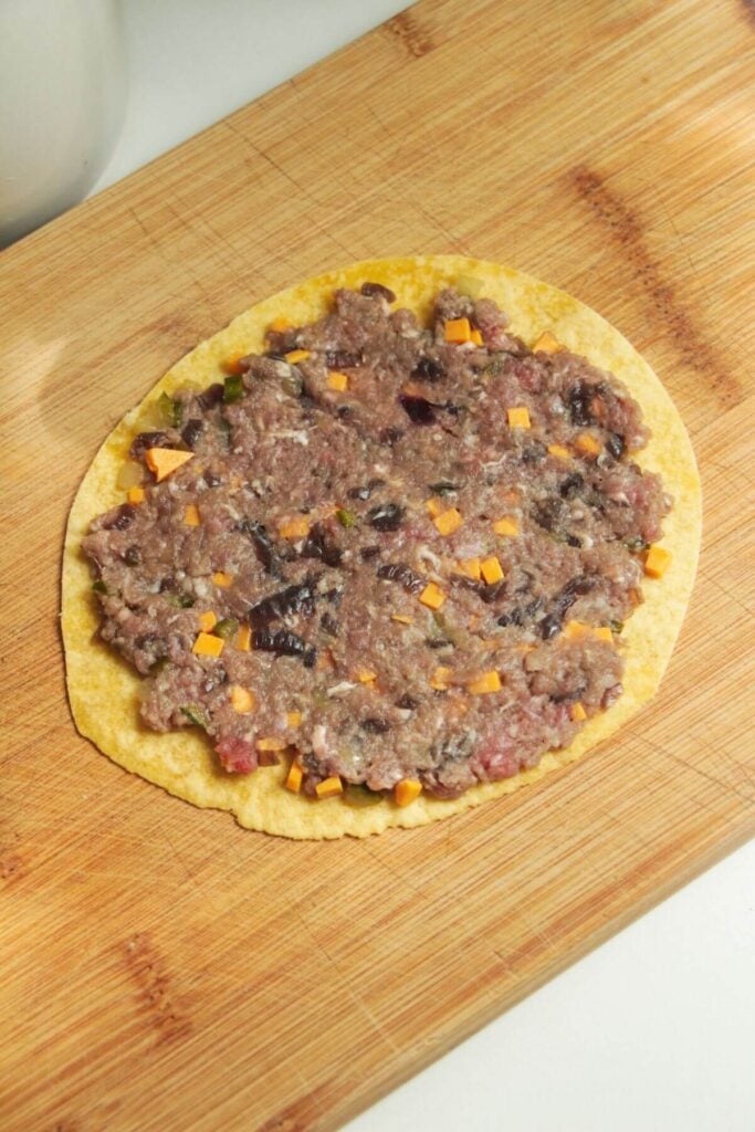 Cheeseburger mixture spread onto taco.