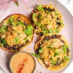 Three smash cheeseburger tacos on a pink plate.