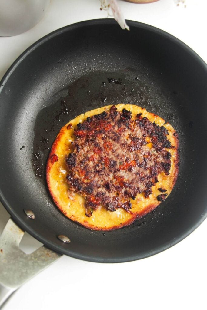 Cooked cheeseburger taco in small pan.