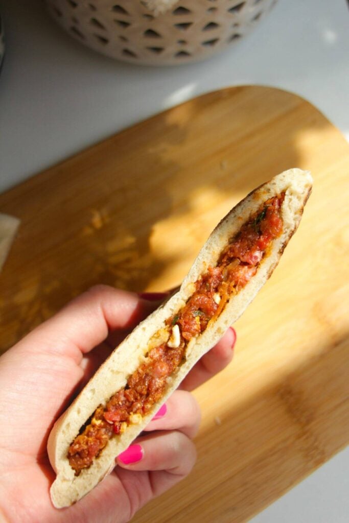 Hand holding stuffed flatbread.