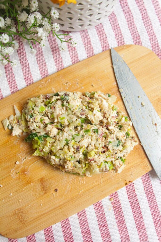 Chopped chicken Caesar filling on a wooden board.