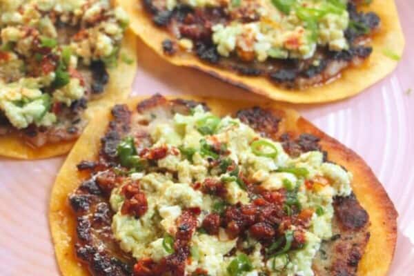 Three smash sausage tacos on a pink plate.