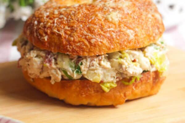 Chicken Caesar salad chopped bagel on a wooden board.