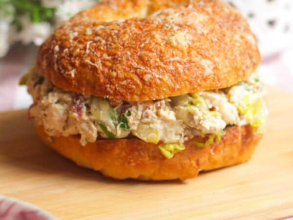 Chicken Caesar salad chopped bagel on a wooden board.