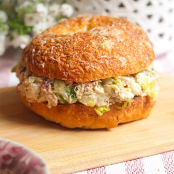 Chicken Caesar salad chopped bagel on a wooden board.