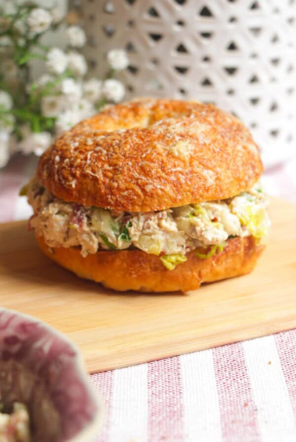 Chicken Caesar salad chopped bagel on a wooden board.