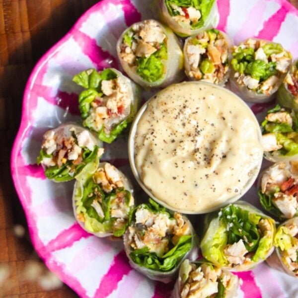 Chicken Caesar rice paper rolls on a pink and white plate.