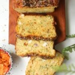 Three slices of zucchini bread on a wooden board.