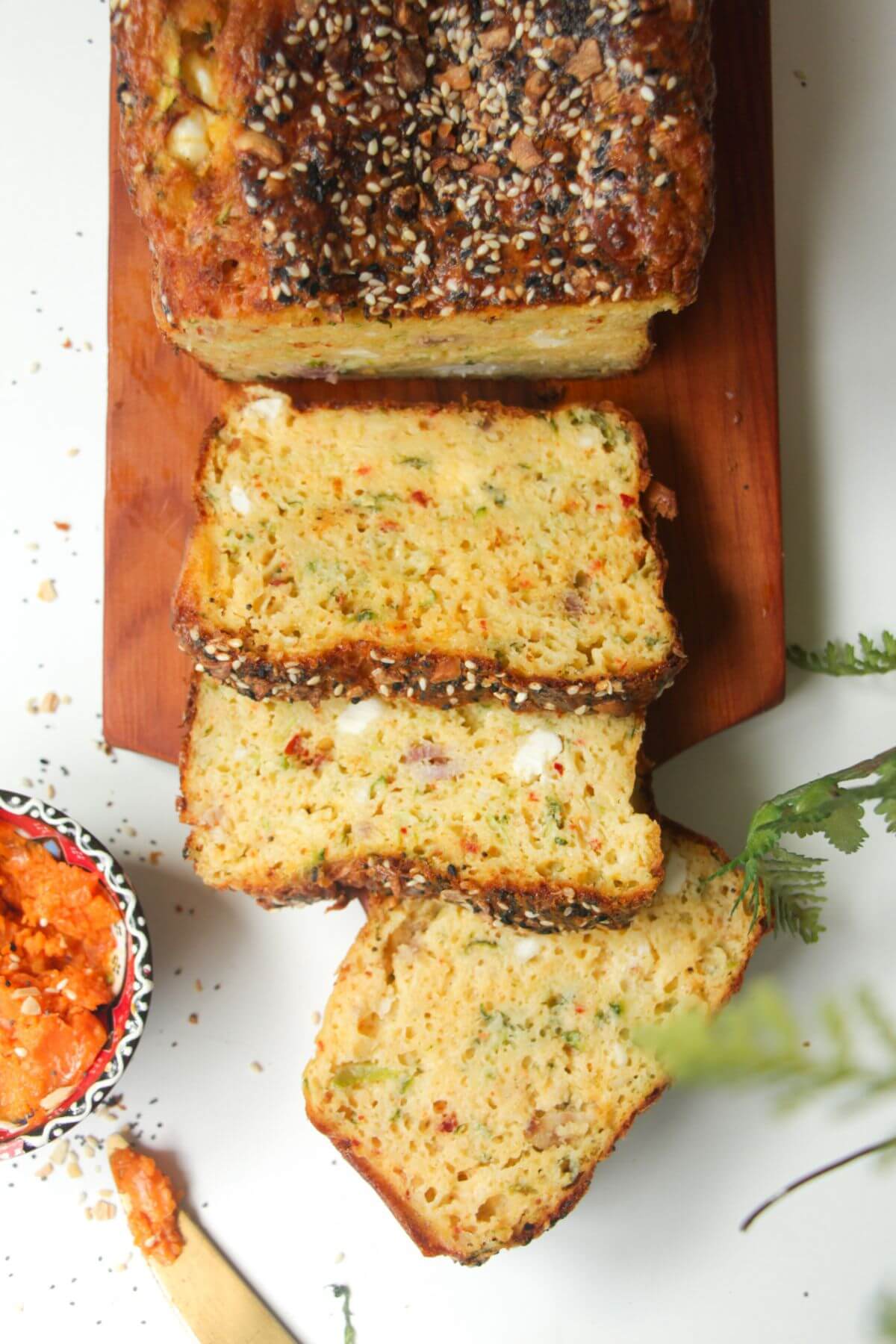 Three slices of zucchini bread on a wooden board.