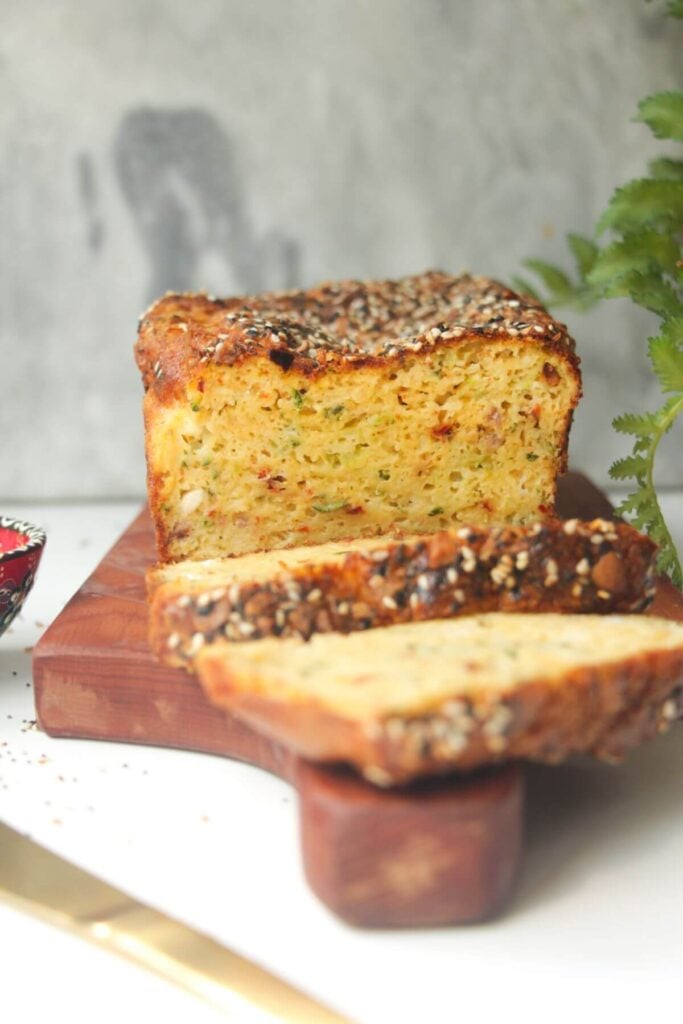 Zucchini bread sliced on a wooden board.