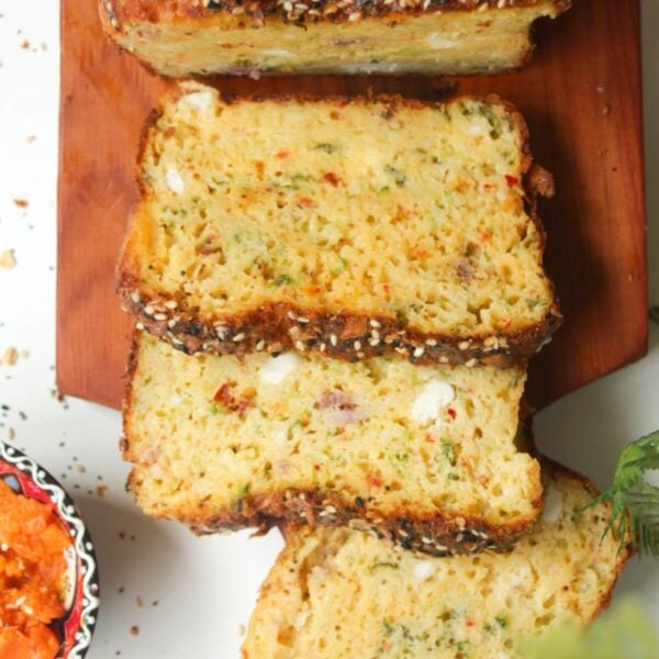 Three slices of zucchini bread on a wooden board.