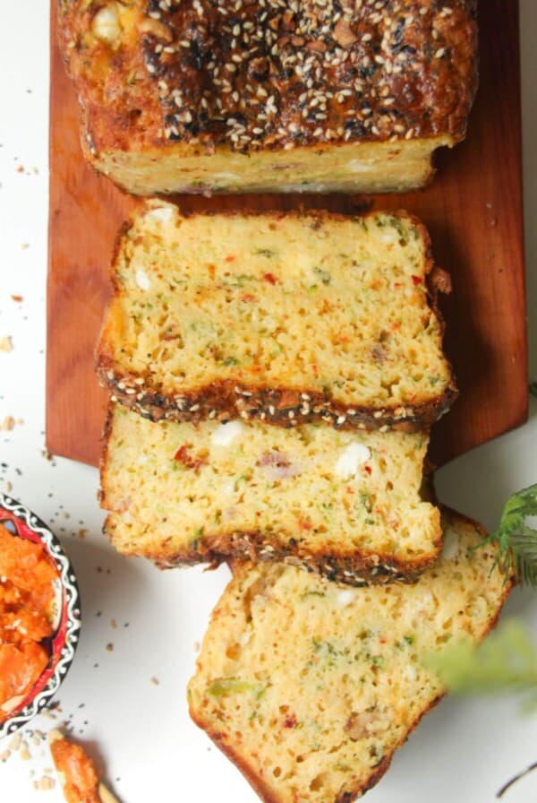 Three slices of zucchini bread on a wooden board.