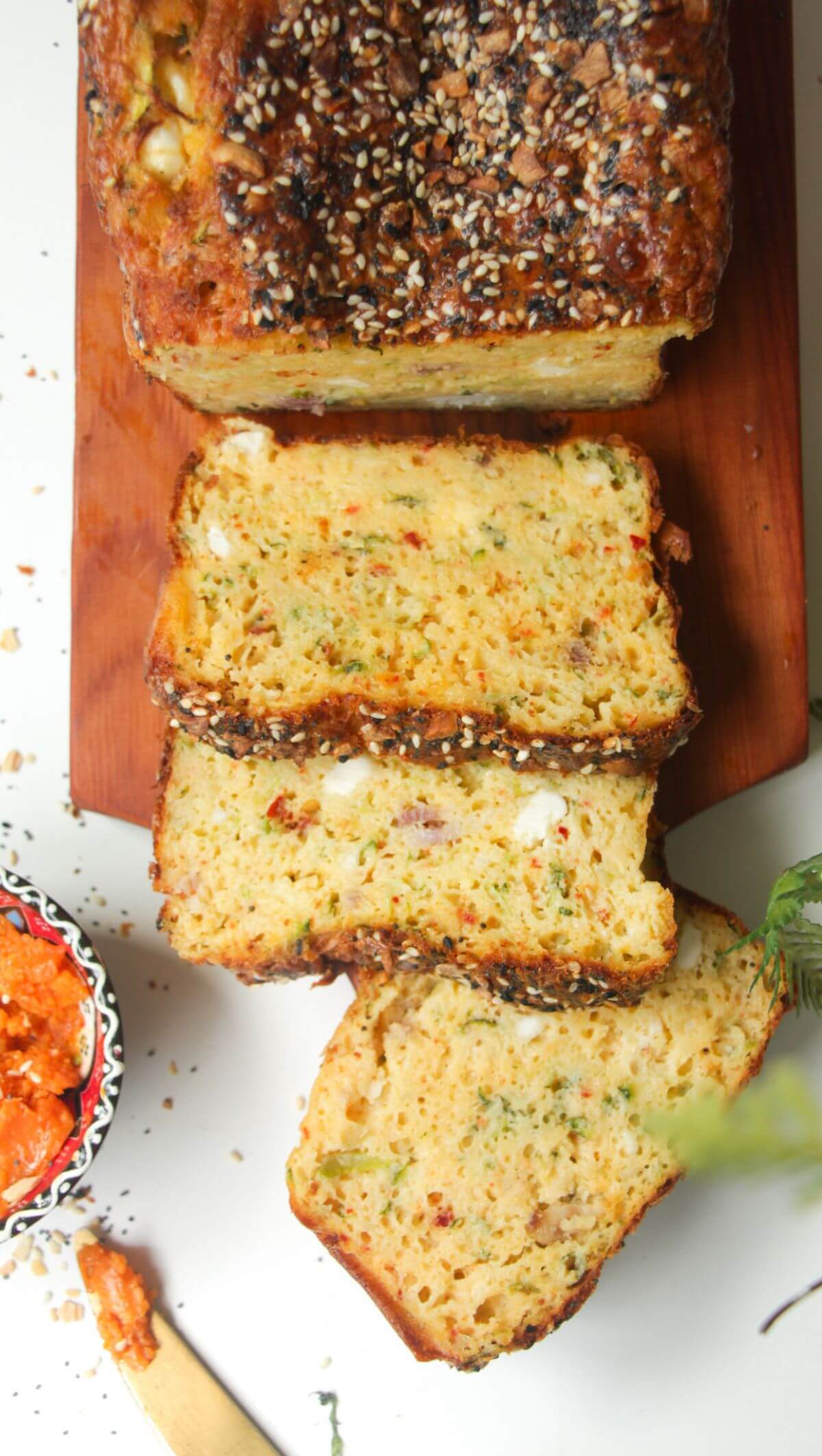 Three slices of zucchini bread on a wooden board.
