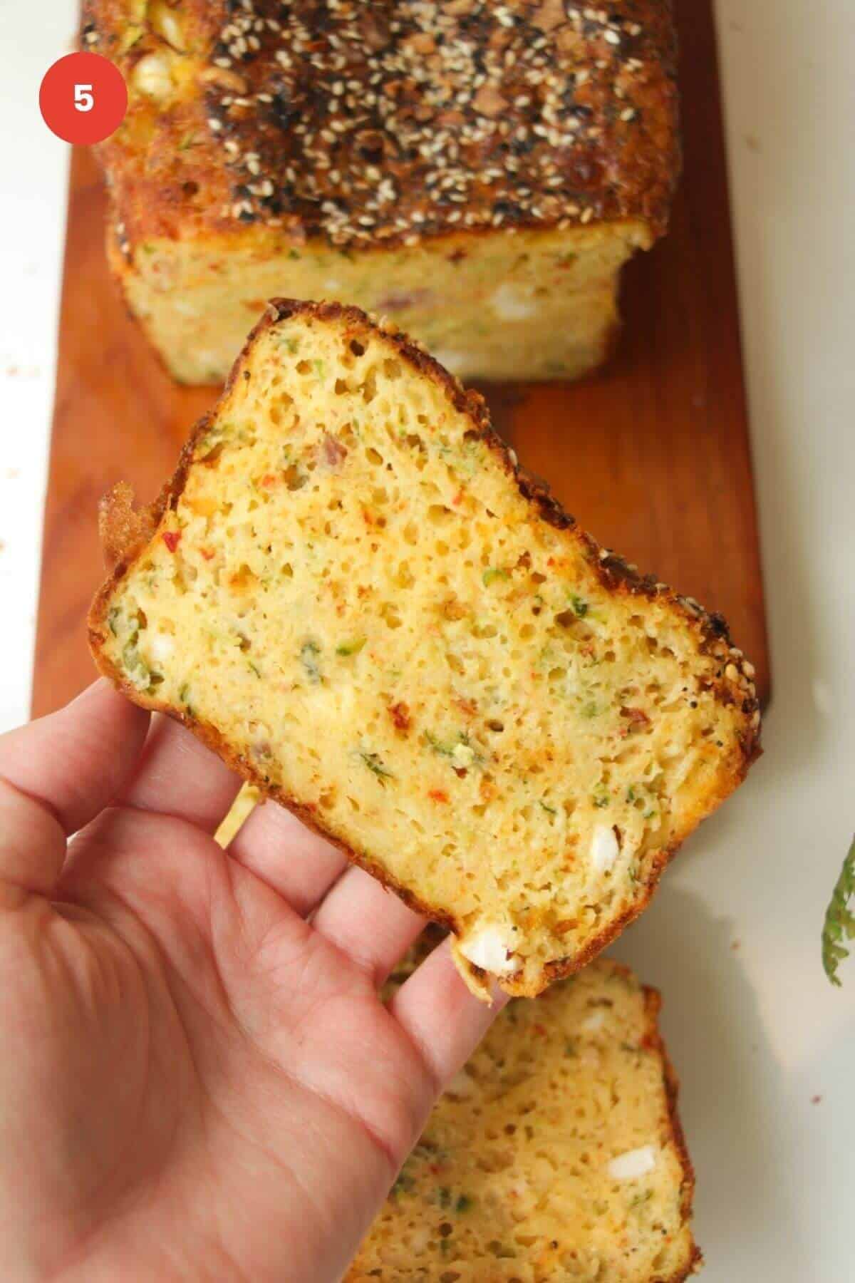 Hand holding sliced zucchini bread.