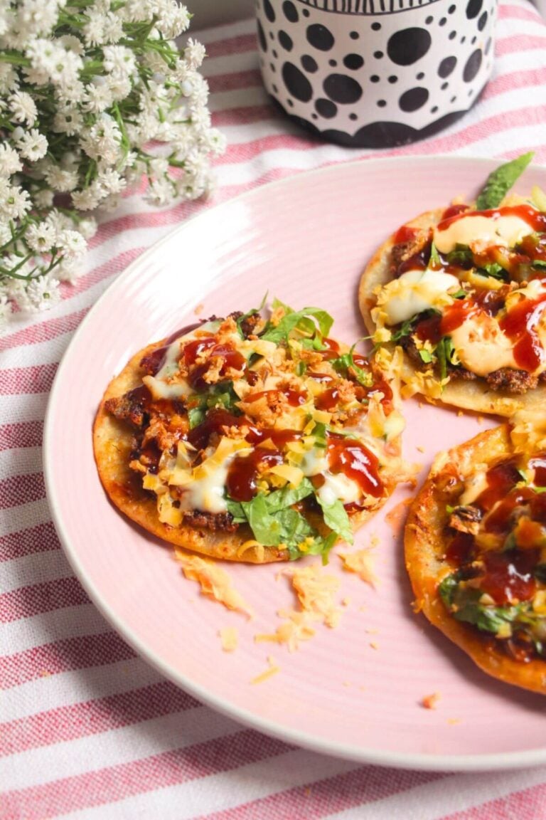 Three BBQ bacon cheeseburger tacos on a plate.