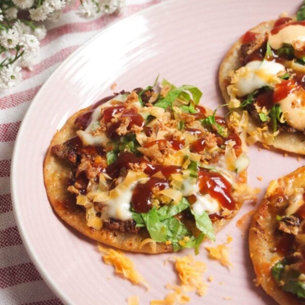 Three BBQ bacon cheeseburger tacos on a plate.