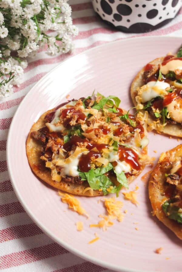 Three BBQ bacon cheeseburger tacos on a plate.